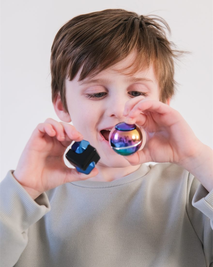A child holding a bopster Spin Ball and Cube Spinner